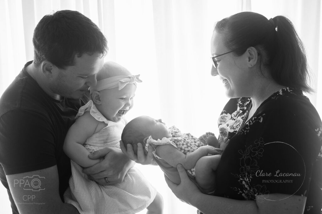 Photograph of a family with a toddler and newborn baby